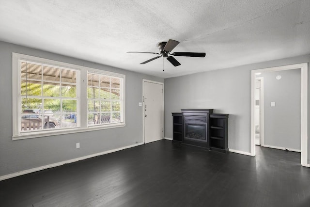 7202 Marcell St, Austin, TX 78752 - unfurnished living room with a fireplace, dark wood-type flooring, ceiling fan, and a textured ceiling