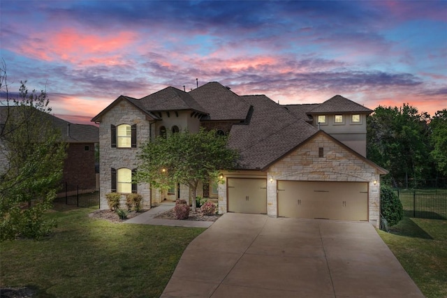 french provincial home with driveway, stone siding, a front yard, fence, and a garage
