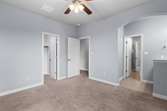 2015 Colina Cv, Cedar Park, TX 78613 - unfurnished bedroom with arched walkways, light colored carpet, a spacious closet, and a ceiling fan