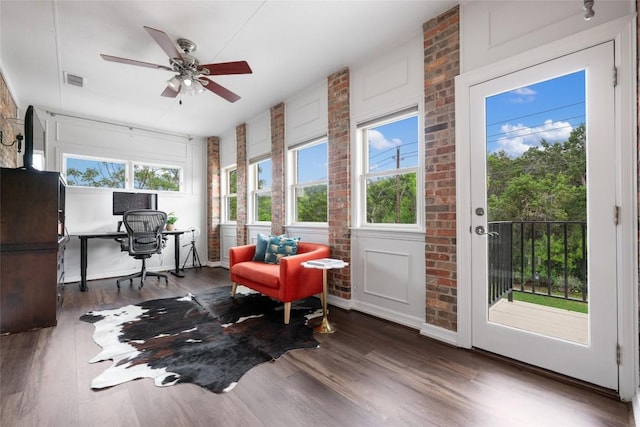 6605 Canon Wren Dr, Austin, TX 78746 - office space featuring wood finished floors, a ceiling fan, and brick wall