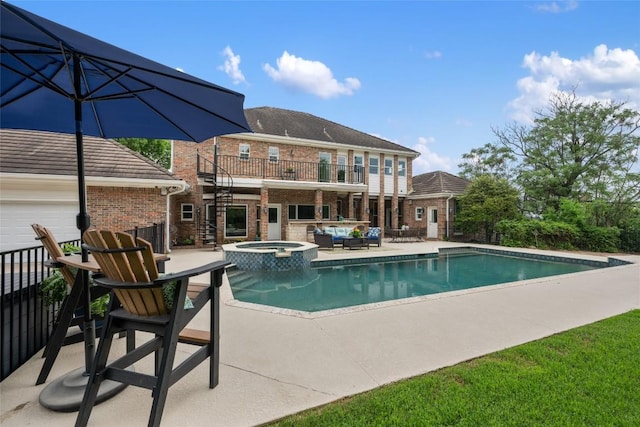 view of pool with a patio area, an outdoor living space, a pool with connected hot tub, and stairway