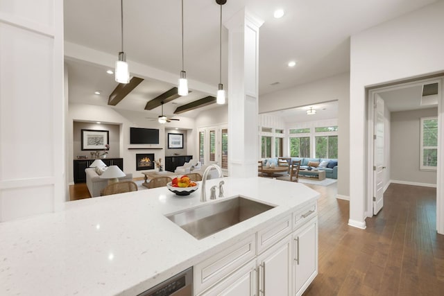 433 Chitalpa St, Leander, TX 78641 - kitchen featuring open floor plan, a sink, a ceiling fan, a lit fireplace, and light stone counters
