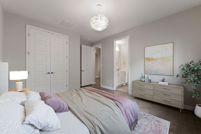 433 Chitalpa St, Leander, TX 78641 - bedroom with a closet, baseboards, dark wood-style flooring, connected bathroom, and a chandelier