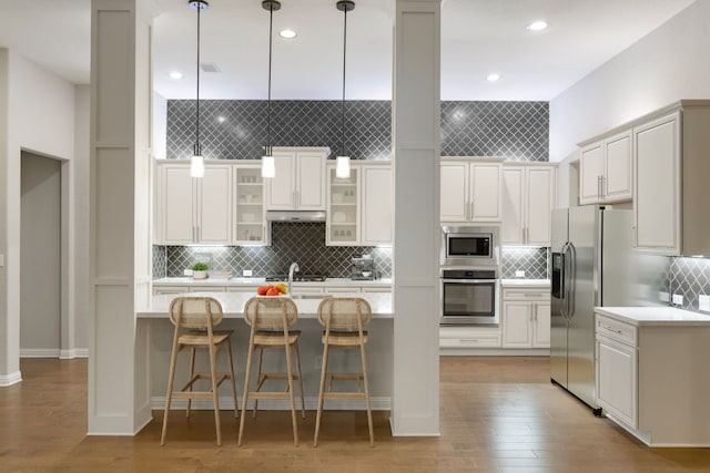 433 Chitalpa St, Leander, TX 78641 - kitchen with stainless steel appliances, light countertops, tasteful backsplash, light wood-style flooring, and recessed lighting