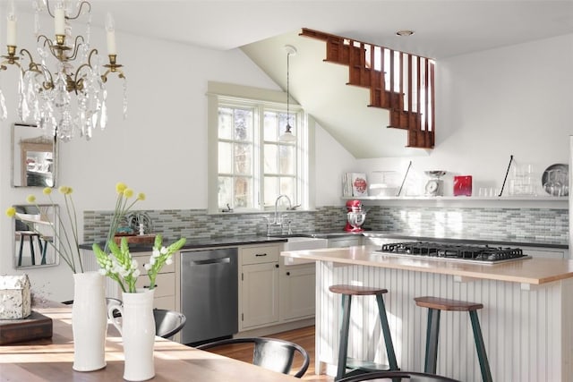 1313 W 9th 1/2 St, Austin, TX 78703 - kitchen with stainless steel appliances, tasteful backsplash, a breakfast bar, and hanging light fixtures