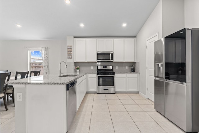 13801 Rosebud Isle Dr, Manor, TX 78653 - kitchen featuring stainless steel appliances, a sink, a peninsula, decorative backsplash, and light stone counters