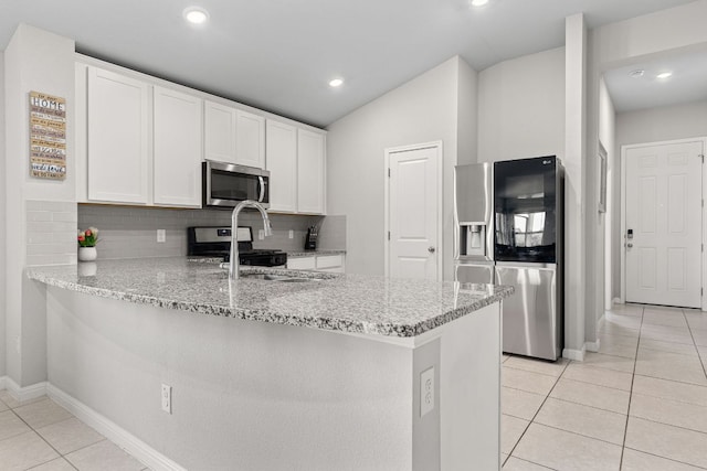 13801 Rosebud Isle Dr, Manor, TX 78653 - kitchen with appliances with stainless steel finishes, a peninsula, light tile patterned floors, light stone countertops, and white cabinetry