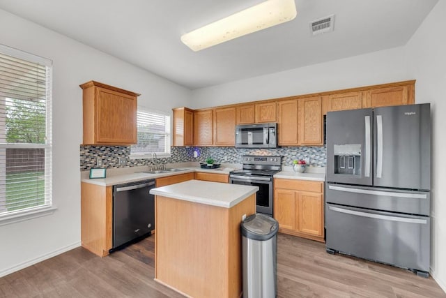 13605 Lyndon B Johnson St, Manor, TX 78653 - kitchen with appliances with stainless steel finishes, light wood finished floors, light countertops, and decorative backsplash
