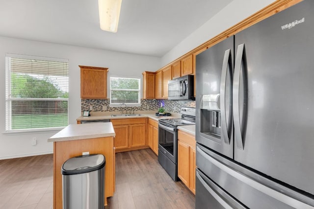 13605 Lyndon B Johnson St, Manor, TX 78653 - kitchen with appliances with stainless steel finishes, decorative backsplash, light countertops, light wood finished floors, and a sink