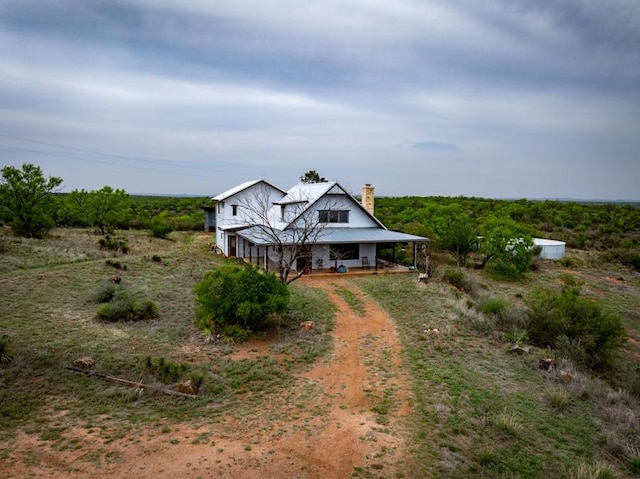 view of front of property featuring a chimney and driveway