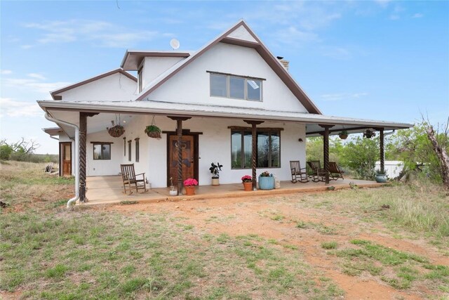 back of property with a patio area and stucco siding