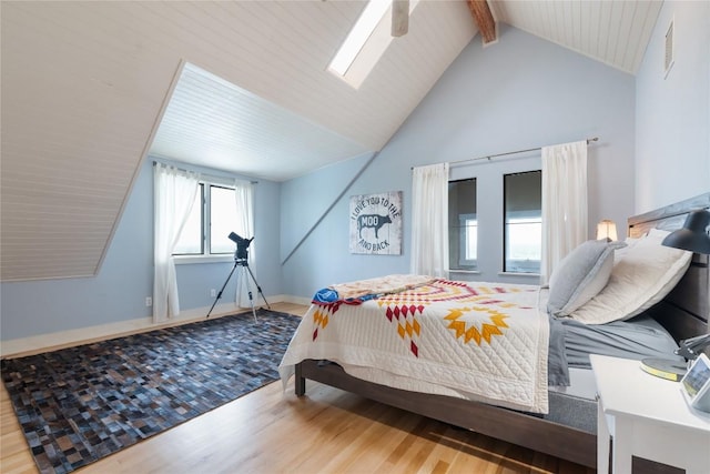 bedroom featuring baseboards, visible vents, beam ceiling, high vaulted ceiling, and wood finished floors