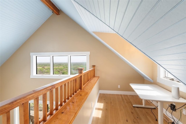 bonus room with baseboards, vaulted ceiling with beams, and wood finished floors