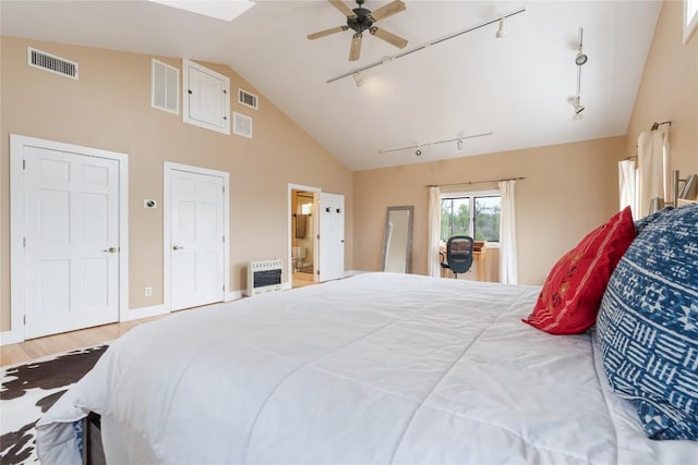 bedroom with visible vents, heating unit, and wood finished floors