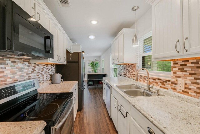 9106 Slayton Dr, Austin, TX 78753 - kitchen featuring appliances with stainless steel finishes, a sink, decorative backsplash, white cabinets, and dark wood-style flooring