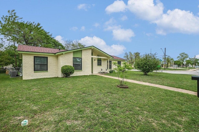 9106 Slayton Dr, Austin, TX 78753 - view of front of home with a front yard, central AC, and brick siding