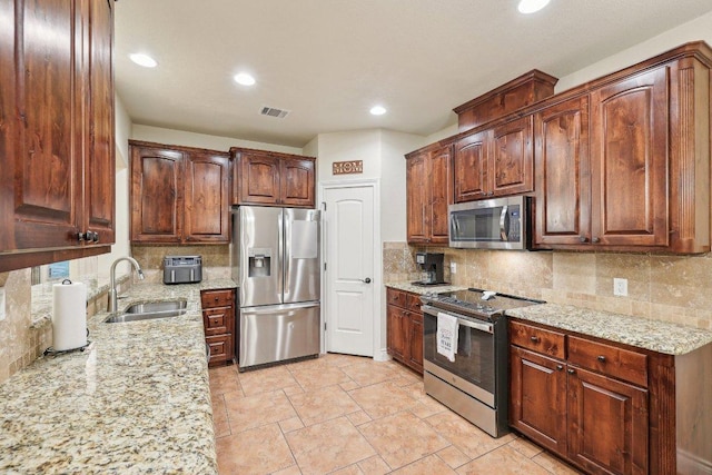 2004 American Dr Unit 1, Lago Vista, TX 78645 - kitchen with appliances with stainless steel finishes, a sink, decorative backsplash, light stone countertops, and recessed lighting