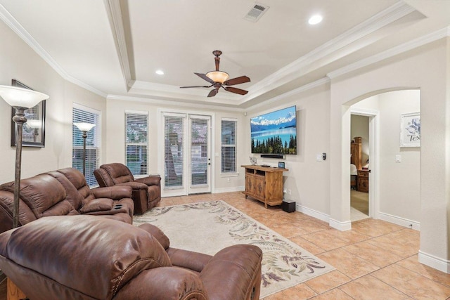 2004 American Dr Unit 1, Lago Vista, TX 78645 - living room featuring a raised ceiling, arched walkways, a ceiling fan, ornamental molding, and light tile patterned floors