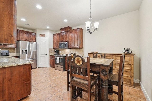 2004 American Dr Unit 1, Lago Vista, TX 78645 - kitchen with stainless steel appliances, tasteful backsplash, a chandelier, light stone counters, and hanging light fixtures