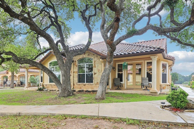 2004 American Dr Unit 1, Lago Vista, TX 78645 - view of front of house with a tile roof, french doors, stone siding, and stucco siding