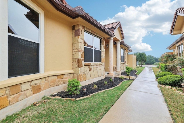 2004 American Dr Unit 1, Lago Vista, TX 78645 - view of property exterior with stone siding, stucco siding, and a tile roof