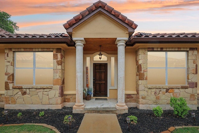 2004 American Dr Unit 1, Lago Vista, TX 78645 - exterior entry at dusk featuring stone siding and a tile roof