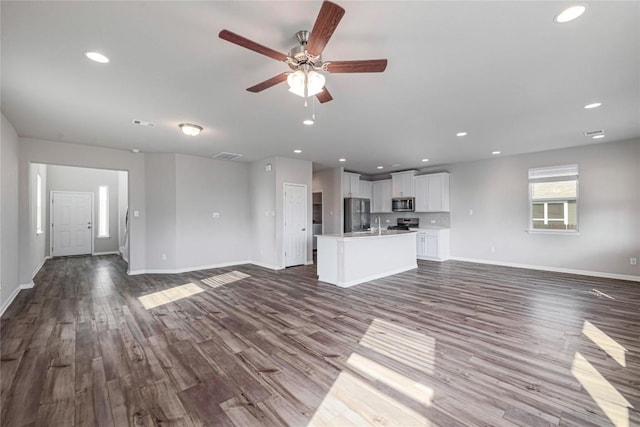 12103 Tolson Dr, Manor, TX 78653 - unfurnished living room featuring dark wood-style flooring, a ceiling fan, and recessed lighting