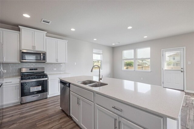 12103 Tolson Dr, Manor, TX 78653 - kitchen featuring stainless steel appliances, dark wood-type flooring, white cabinetry, backsplash, and recessed lighting