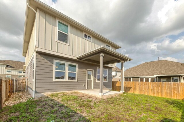 12103 Tolson Dr, Manor, TX 78653 - back of house with board and batten siding, a patio area, and a fenced backyard