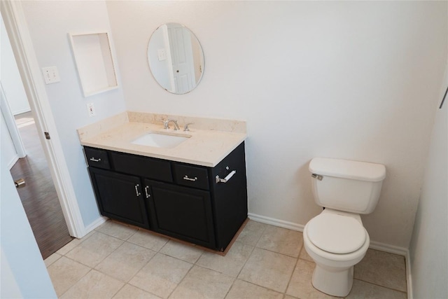 bathroom with tile patterned floors, vanity, toilet, and baseboards