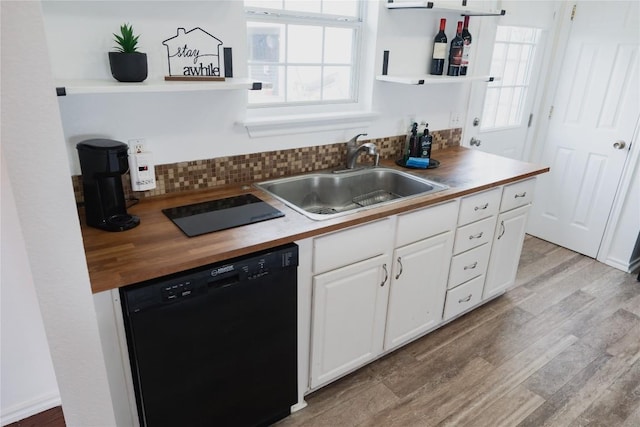 kitchen with open shelves, a sink, wood counters, light wood-style floors, and black dishwasher