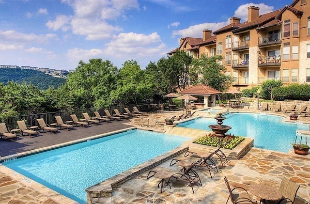 community pool featuring fence and a patio