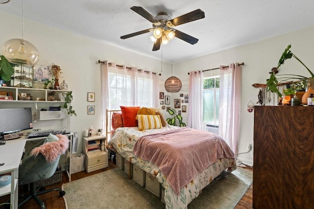 1403 Ashwood Rd, Austin, TX 78722 - bedroom with wood finished floors, multiple windows, an office area, and a ceiling fan