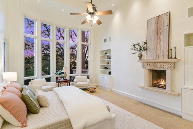4646 Rockcliff Rd, Austin, TX 78746 - bedroom with carpet, a towering ceiling, and a lit fireplace