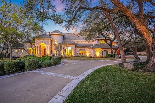4646 Rockcliff Rd, Austin, TX 78746 - view of front of house featuring stone siding, stucco siding, a yard, and curved driveway