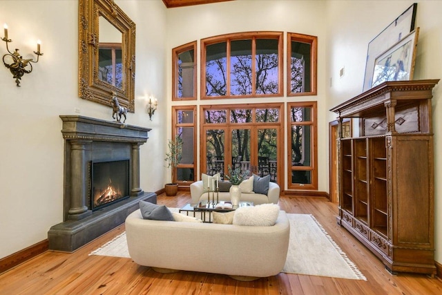 4646 Rockcliff Rd, Austin, TX 78746 - living area with a towering ceiling, a warm lit fireplace, and wood finished floors