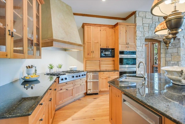 4646 Rockcliff Rd, Austin, TX 78746 - kitchen with stainless steel appliances, custom exhaust hood, crown molding, light wood-type flooring, and glass insert cabinets