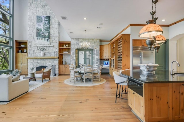 4646 Rockcliff Rd, Austin, TX 78746 - kitchen with a chandelier, a warming drawer, a fireplace, light wood-style floors, and decorative light fixtures