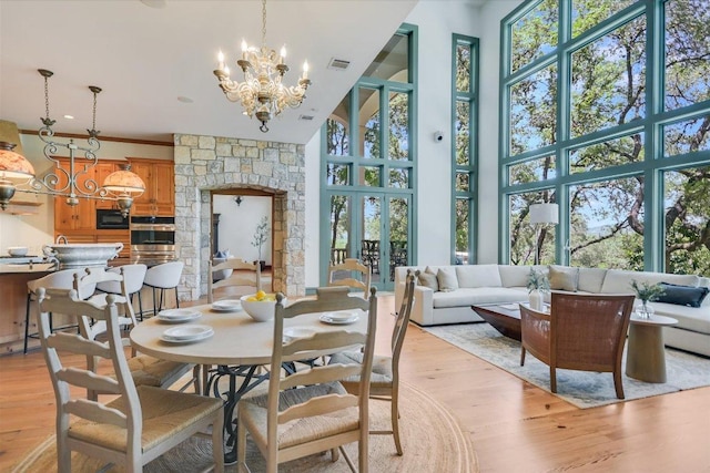 4646 Rockcliff Rd, Austin, TX 78746 - dining space with a towering ceiling, light wood finished floors, and a chandelier
