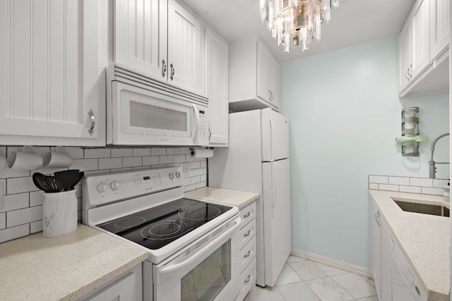 2450 Ashdale Dr Unit D-206, Austin, TX 78757 - kitchen with white appliances, white cabinetry, decorative backsplash, and a chandelier