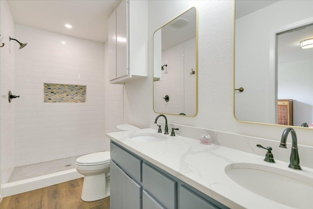1710 County Road 128, Burnet, TX 78611 - bathroom with a tile shower, double vanity, wood finished floors, and recessed lighting