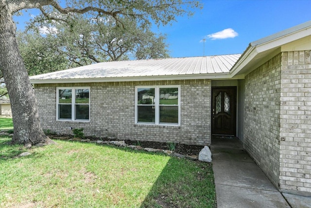 1710 County Road 128, Burnet, TX 78611 - entrance to property featuring a lawn, a metal roof, and brick siding