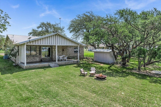 1710 County Road 128, Burnet, TX 78611 - back of property with a fire pit, board and batten siding, a storage shed, a yard, and a patio area