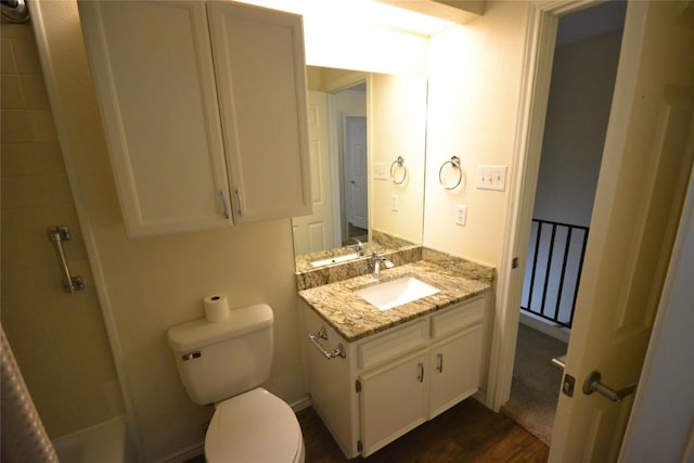 full bath featuring toilet, vanity, tiled shower, and wood finished floors