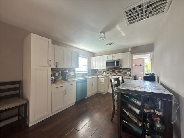 714 Miriam St, Baytown, TX 77520 - kitchen featuring dark wood-style flooring, visible vents, tasteful backsplash, and appliances with stainless steel finishes