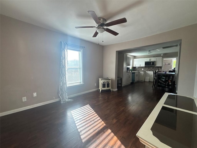 714 Miriam St, Baytown, TX 77520 - living area featuring ceiling fan, dark wood-type flooring, baseboards, and a healthy amount of sunlight