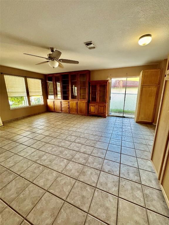 700 Lago Vista St, San Marcos, TX 78666 - empty room with a textured ceiling, light tile patterned floors, a ceiling fan, and visible vents