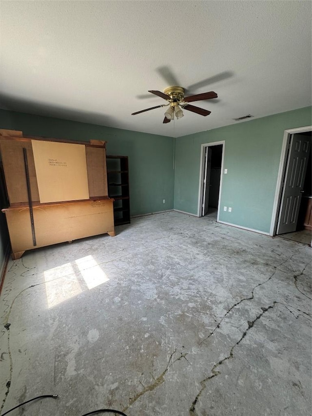 700 Lago Vista St, San Marcos, TX 78666 - unfurnished bedroom featuring a textured ceiling, baseboards, a ceiling fan, and visible vents