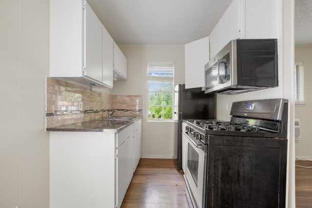 5300 Guadalupe St Unit 6202, Austin, TX 78751 - kitchen featuring stainless steel microwave, gas stove, light wood-style floors, and decorative backsplash