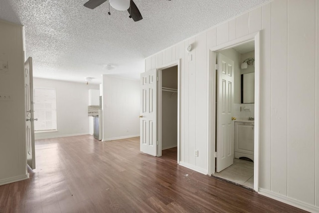 5300 Guadalupe St Unit 6202, Austin, TX 78751 - unfurnished bedroom featuring wood finished floors, a textured ceiling, a walk in closet, connected bathroom, and ceiling fan